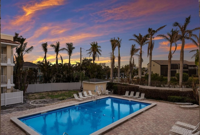 community pool with a patio area and fence