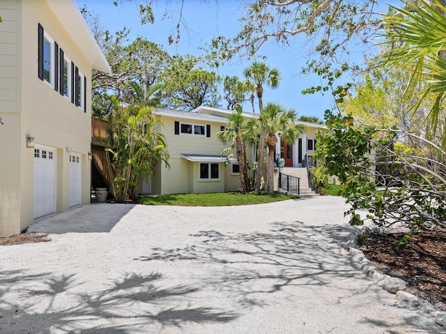 7320 Melaleuca Way, Siesta Key, FL 34242 - view of front of house featuring a garage, stucco siding, and driveway