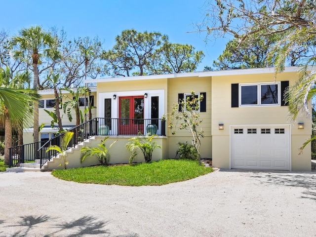 7320 Melaleuca Way, Siesta Key, FL 34242 - view of front facade with a garage, driveway, and french doors