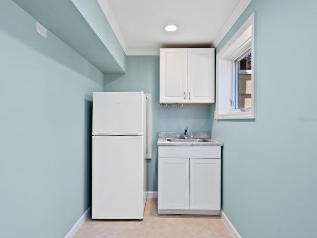 7320 Melaleuca Way, Siesta Key, FL 34242 - kitchen with freestanding refrigerator, a sink, ornamental molding, white cabinetry, and light tile patterned floors