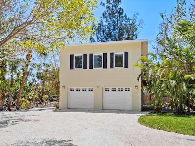 7320 Melaleuca Way, Siesta Key, FL 34242 - view of front of home with an attached garage, driveway, and stucco siding
