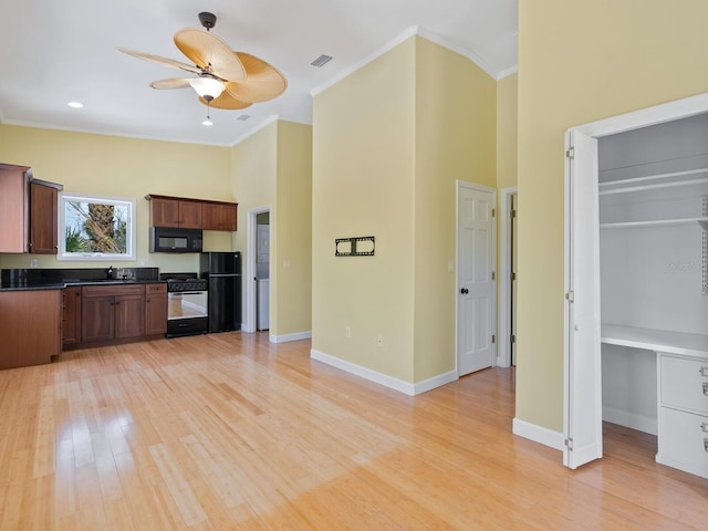 7320 Melaleuca Way, Siesta Key, FL 34242 - kitchen with black microwave, gas range oven, dark countertops, crown molding, and a sink