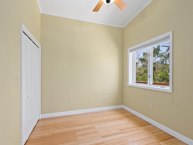 7320 Melaleuca Way, Siesta Key, FL 34242 - unfurnished bedroom with ornamental molding, light wood-style flooring, a closet, baseboards, and a ceiling fan