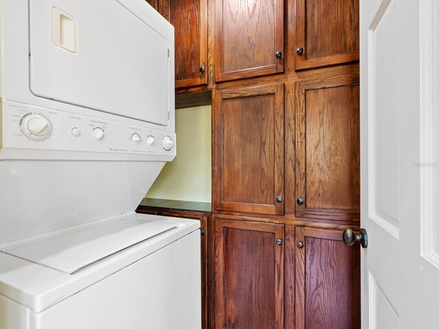 7320 Melaleuca Way, Siesta Key, FL 34242 - washroom with stacked washer / dryer and cabinet space