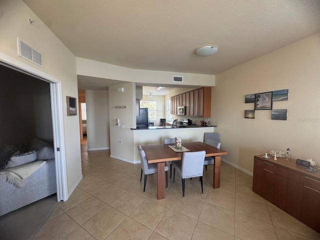 7911 Grand Estuary Trl Unit 201, Bradenton, FL 34212 - dining space with light tile patterned floors, baseboards, and a textured ceiling