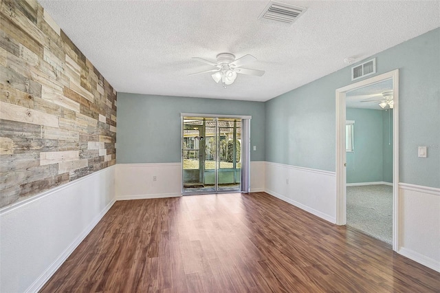602 Park Cir, Bradenton, FL 34207 - spare room with a ceiling fan, wood finished floors, a textured ceiling, and wainscoting