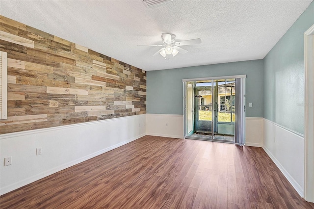 602 Park Cir, Bradenton, FL 34207 - spare room with wood walls, a ceiling fan, wood finished floors, and a textured ceiling