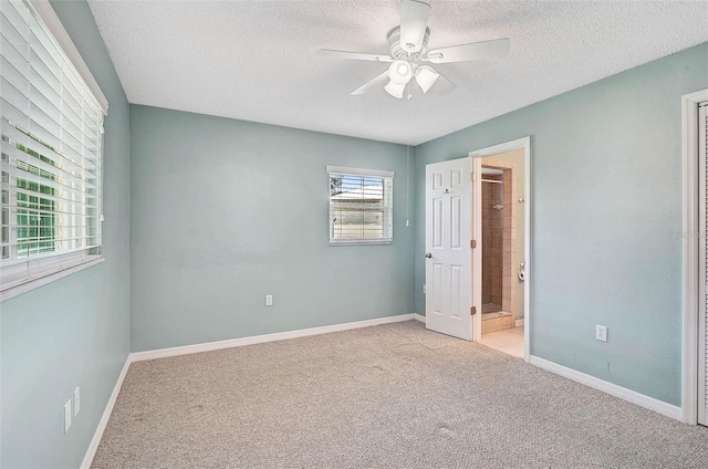 602 Park Cir, Bradenton, FL 34207 - unfurnished bedroom with light colored carpet, a textured ceiling, baseboards, connected bathroom, and a ceiling fan