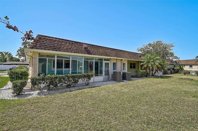 602 Park Cir, Bradenton, FL 34207 - back of property featuring a yard, central AC, roof with shingles, and mansard roof