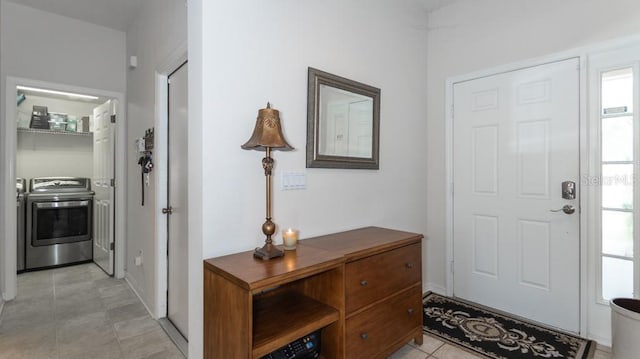 foyer featuring separate washer and dryer and light tile patterned flooring