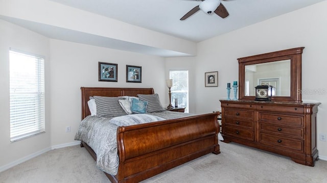 bedroom featuring light colored carpet, multiple windows, and baseboards