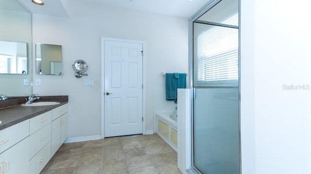 bathroom featuring a bath, double vanity, and baseboards