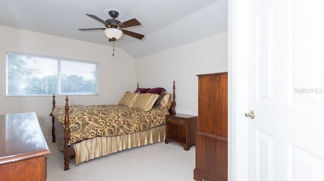 bedroom featuring vaulted ceiling, light carpet, and ceiling fan