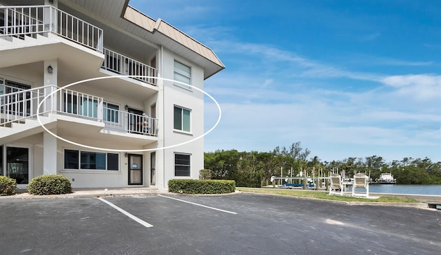 view of property featuring uncovered parking and a water view