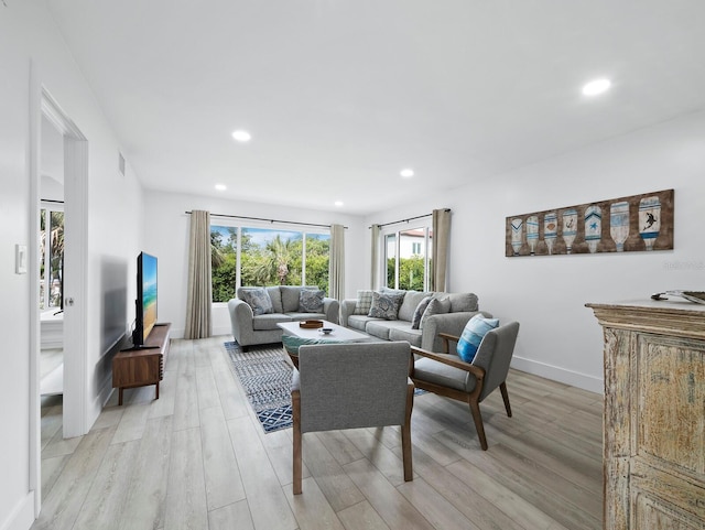 living room with light wood-style flooring, plenty of natural light, recessed lighting, and baseboards