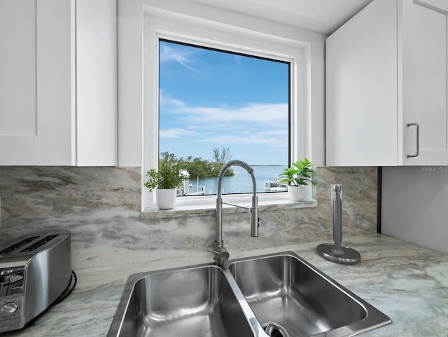kitchen featuring a sink, white cabinetry, and tasteful backsplash