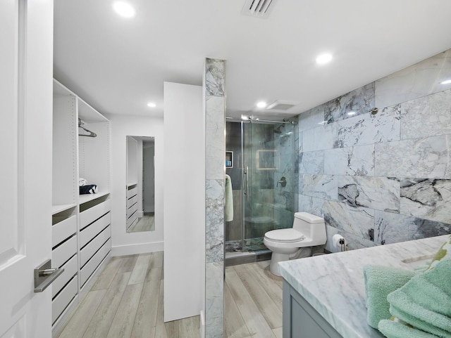 full bath featuring vanity, a shower stall, recessed lighting, toilet, and wood finished floors