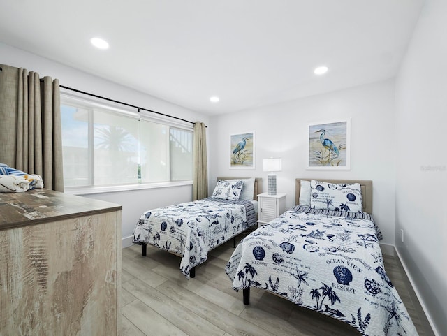 bedroom featuring light wood finished floors, baseboards, and recessed lighting