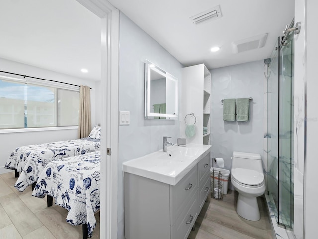 ensuite bathroom with wood finished floors, toilet, vanity, a stall shower, and recessed lighting