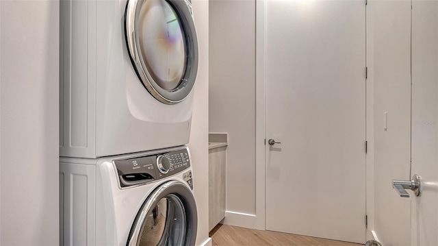 33 S Palm Ave Unit 1303, Sarasota, FL 34236 - laundry room featuring stacked washing machine and dryer, light wood finished floors, and cabinet space