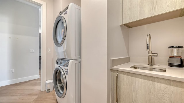 33 S Palm Ave Unit 1303, Sarasota, FL 34236 - clothes washing area with stacked washer / drying machine, light wood finished floors, and baseboards