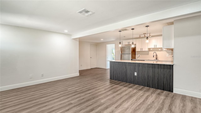 1227 Porpoise Rd, Venice, FL 34293 - kitchen featuring baseboards, freestanding refrigerator, a peninsula, white cabinets, and recessed lighting