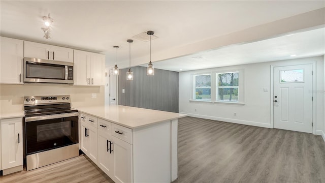 1227 Porpoise Rd, Venice, FL 34293 - kitchen with stainless steel appliances, light wood-type flooring, a peninsula, light countertops, and white cabinetry