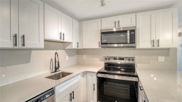 1227 Porpoise Rd, Venice, FL 34293 - kitchen featuring appliances with stainless steel finishes, a sink, white cabinetry, and light countertops