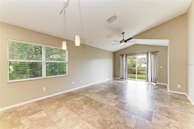 empty room with ceiling fan, light stone finish floors, baseboards, and vaulted ceiling