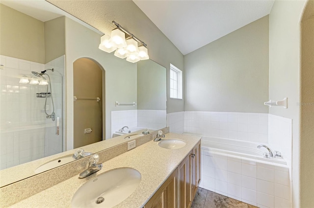bathroom featuring a stall shower, a garden tub, tile patterned flooring, and double vanity