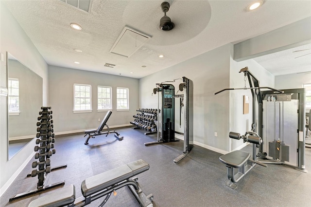 gym with a textured ceiling, recessed lighting, baseboards, and attic access