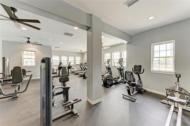 gym featuring ceiling fan, a textured ceiling, plenty of natural light, recessed lighting, and baseboards