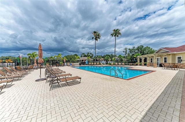 community pool with fence and a patio area