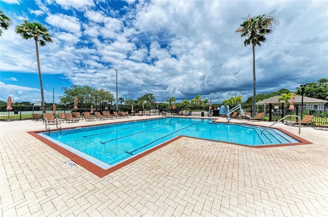 community pool featuring fence and a patio area
