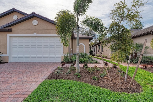 12091 Firewheel Pl, Venice, FL 34293 - view of front of house with stucco siding, decorative driveway, and an attached garage