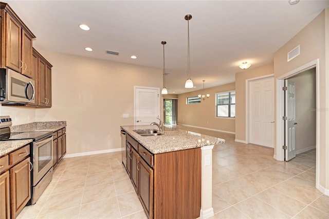 12091 Firewheel Pl, Venice, FL 34293 - kitchen with stainless steel appliances, light tile patterned floors, a sink, a center island with sink, and recessed lighting