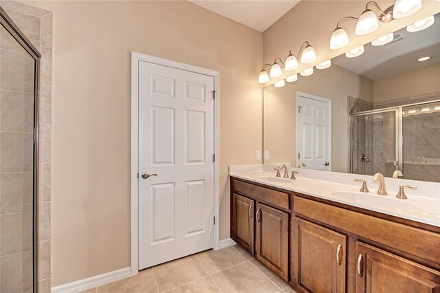 12091 Firewheel Pl, Venice, FL 34293 - full bath with a shower stall, double vanity, tile patterned flooring, and baseboards