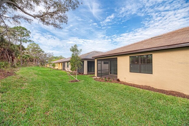 12091 Firewheel Pl, Venice, FL 34293 - view of grassy yard with a sunroom