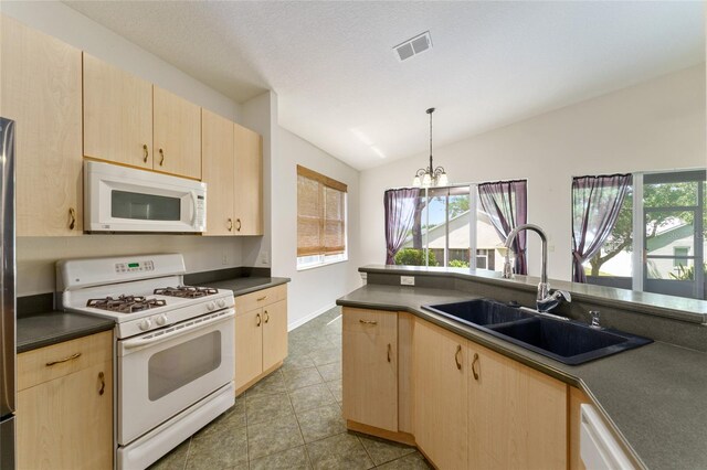 777 Summit Greens Blvd, Clermont, FL 34711 - kitchen with white appliances, light brown cabinetry, a sink, dark countertops, and a chandelier