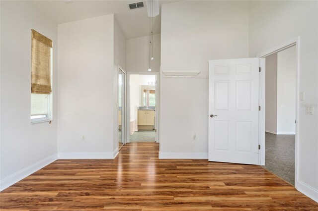 777 Summit Greens Blvd, Clermont, FL 34711 - empty room featuring a high ceiling, wood finished floors, plenty of natural light, and baseboards