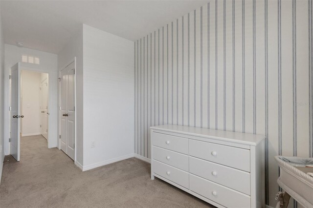 bedroom featuring light carpet, baseboards, and wallpapered walls