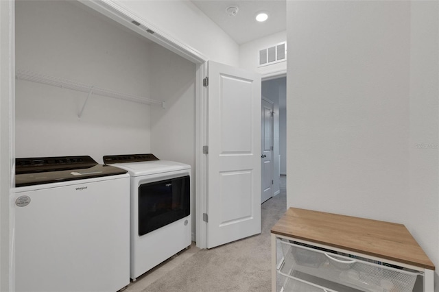 clothes washing area featuring washing machine and dryer and light carpet