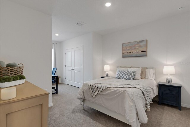 bedroom featuring light colored carpet, baseboards, recessed lighting, and a closet