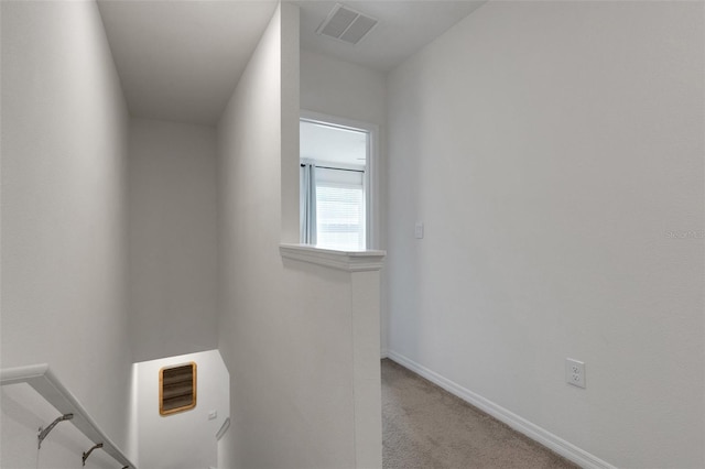 corridor with an upstairs landing, carpet, and baseboards