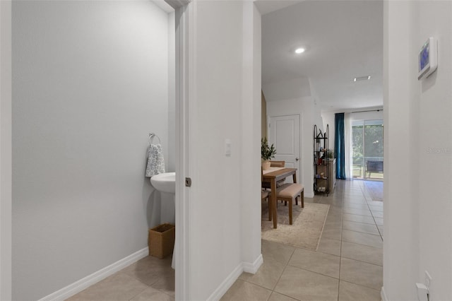 corridor with light tile patterned flooring, baseboards, and recessed lighting