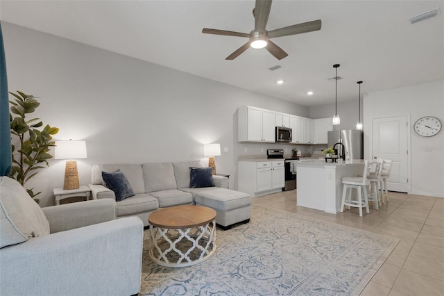 living room with light tile patterned floors, ceiling fan, recessed lighting, and baseboards
