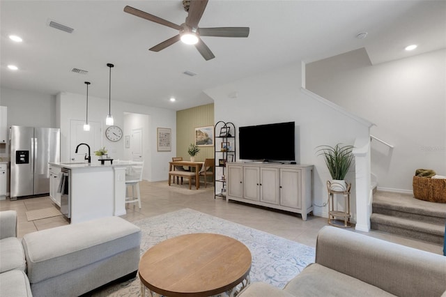 living area featuring light tile patterned flooring, a ceiling fan, stairs, recessed lighting, and baseboards