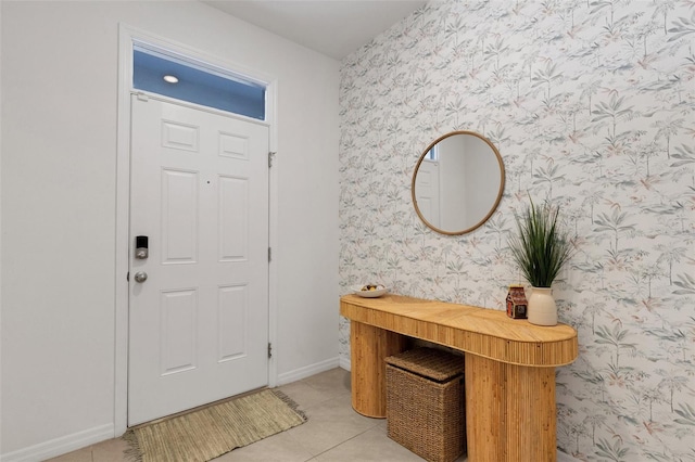 entryway with wallpapered walls, light tile patterned floors, and baseboards