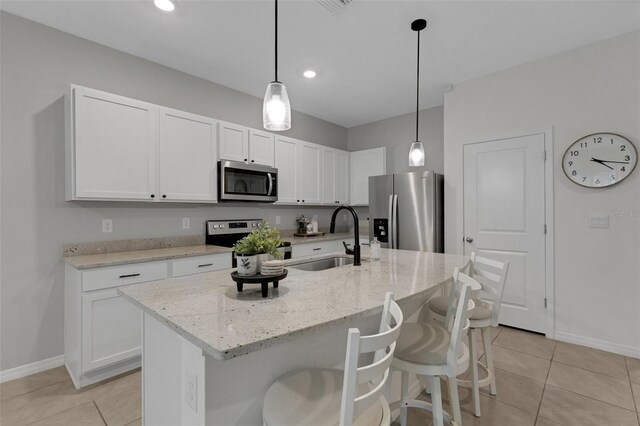 kitchen with stainless steel appliances, a sink, baseboards, white cabinets, and recessed lighting