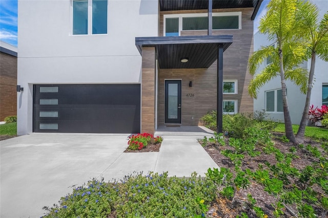 4726 Rivetta Ct, Sarasota, FL 34231 - view of exterior entry featuring an attached garage, driveway, and stucco siding